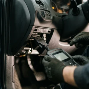 Engine Light hub hero, an OBD2 scanner plugged into a diagnostic port showing a code in soft cabin light