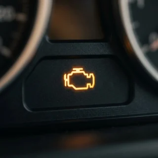 Check Engine Light, a soft amber check-engine warning glow on a dashboard cluster